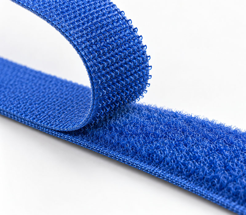 Chiusura a strappo blu – Mavintar Dettaglio illustrativo di una chiusura a strappo blu con uncini e asole.